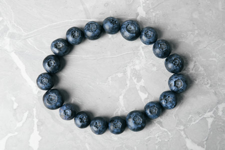 Frame made with fresh blueberries on gray table, top view. Space for textの写真素材