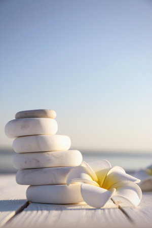 Stack of white marble stones and beautiful flower on wooden deck, space for text. Zen conceptの写真素材