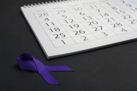 Purple awareness ribbon and calendar on black backgroundの写真素材