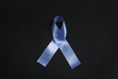 Purple awareness ribbon on black background, top viewの写真素材