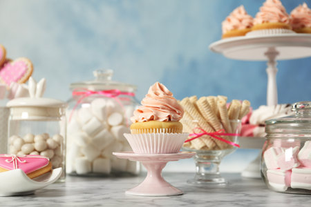 Stand with cupcake and other sweets on white marble table. candy barの写真素材