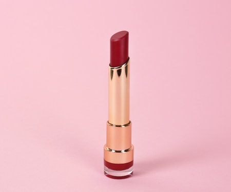 Bright lipstick in gold tube on pink backgroundの写真素材