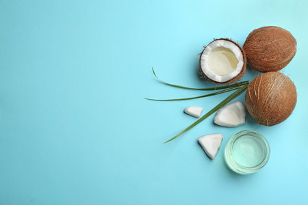 Flat lay composition with ripe coconuts, natural organic oil and space for text on blue backgroundの写真素材