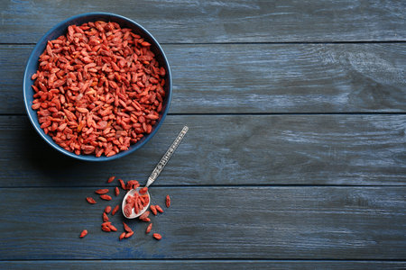 Flat lay composition with dried goji berries on blue wooden table, space for text. healthy superfoodの写真素材