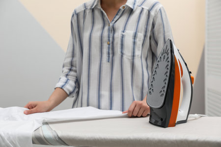Woman ironing clean shirt on board against color background, closeup with space for text. laundry dayの写真素材