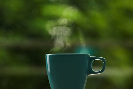 Cup of hot drink against blurred background, space for textの写真素材