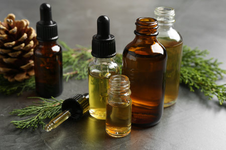 Composition with bottles of conifer essential oil on gray tableの写真素材