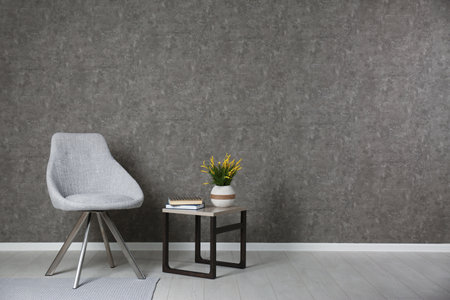 Room interior with modern chair and table at gray wallの写真素材