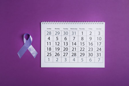 Purple awareness ribbon and calendar on color backgroundの写真素材