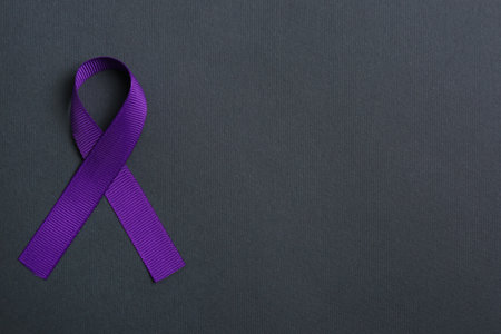 Purple awareness ribbon on black background, top view with space for textの写真素材
