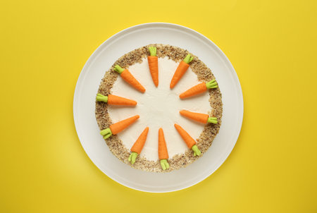 Dish with tasty carrot cake on yellow background, top viewの写真素材