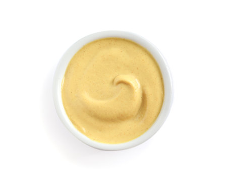Delicious mustard in bowl on white background, top view. spicy sauceの写真素材