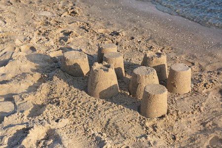 View of the beach with little sand figures near the sea on a sunny summer day