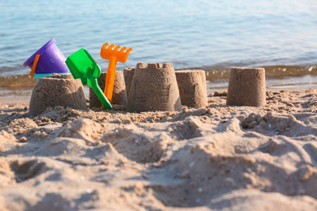Little sand figures and plastic toys on the beach near the seaの写真素材