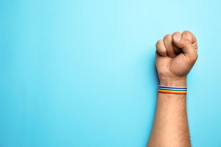Man with rainbow ribbon on blue background, top view and space for text. gay symbolの写真素材