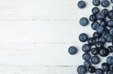 Tasty fresh blueberries on white wooden table, top view with space for textの写真素材