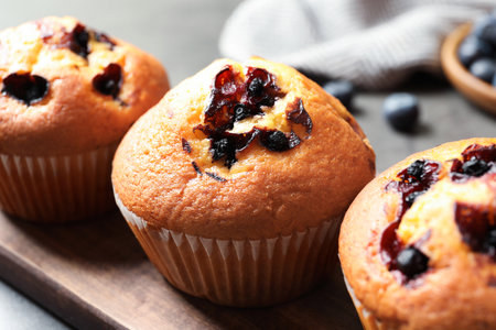 Tasty blueberry muffins on wooden board, closeup viewの写真素材