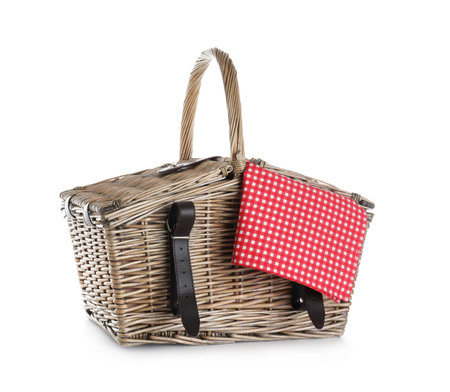 Closed wicker picnic basket with checkered tablecloth on white backgroundの写真素材