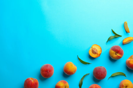 Flat lay composition with fresh peaches on blue background. Space for textの写真素材
