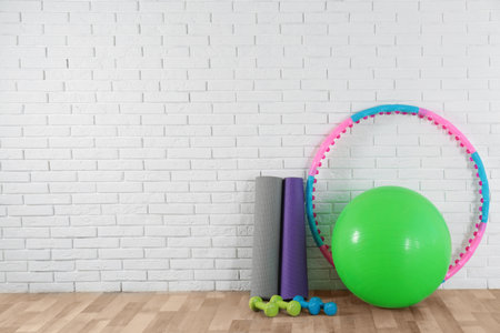 Set of fitness inventory on floor near white brick wall, space for text. Rehabilitation medicineの写真素材