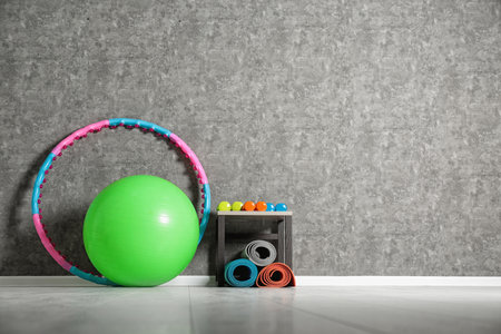 Set of fitness inventory on floor near gray wall, space for text. Rehabilitation medicineの写真素材