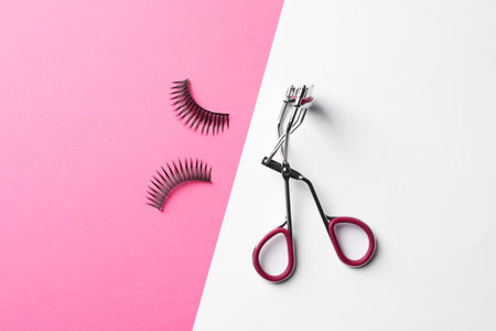 False eyelashes and curler on color background, flat layの写真素材