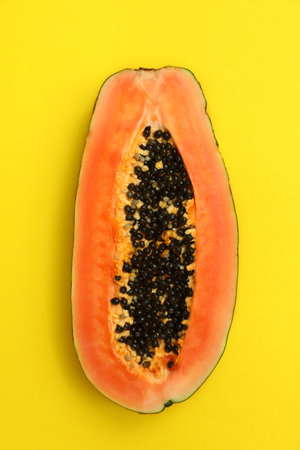 Fresh juicy halved papaya on yellow background, top viewの写真素材