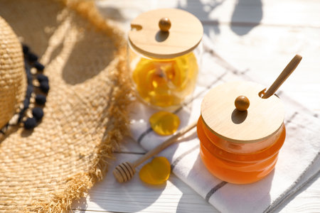 Composition with glass jar of fresh rose honey on white wooden table. Space for textの写真素材
