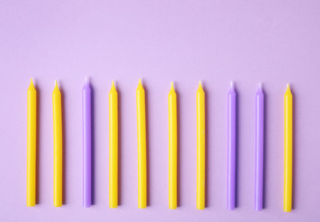 Colorful birthday candles on lilac background, flat layの写真素材
