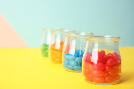 Jars of colorful jelly beans on table. Space for textの写真素材