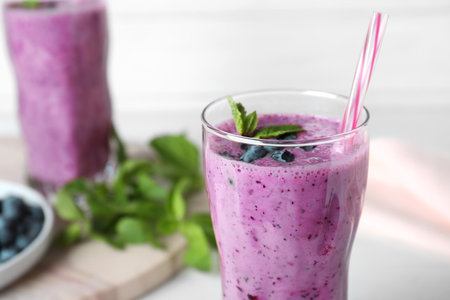 Glass of tasty blueberry smoothie on table, closeupの写真素材
