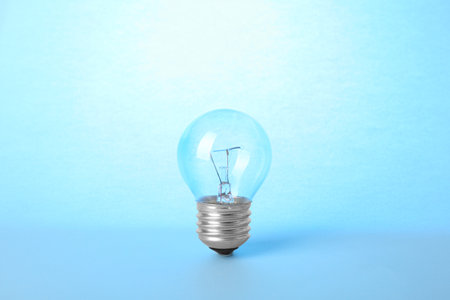 New modern lamp bulb on light blue backgroundの写真素材
