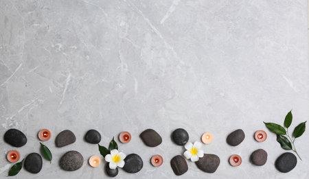 Flat lay composition with spa stones and lit candles on gray marble background, space for textの写真素材