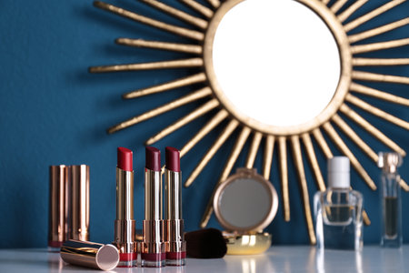 Bright lipsticks in gold tubes on dressing table, space for textの写真素材