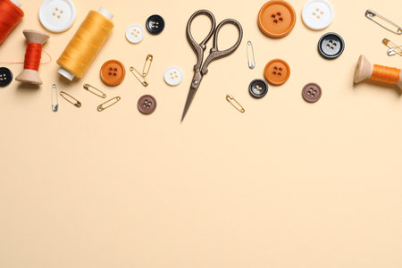 Flat lay composition with scissors and other sewing accessories on light yellow background, space for textの写真素材