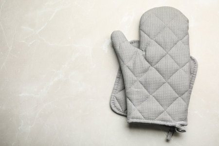 Oven mitt, pot holder and space for text on light stone background, flat layの写真素材