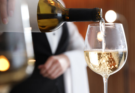 Waitress pouring wine into glass in restaurant, closeupの写真素材