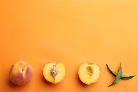 Flat lay composition with fresh peaches on orange background. Space for textの写真素材