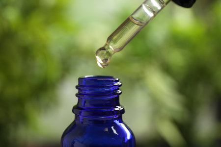 Pipette and bottle of essential oil on blurred background, closeupの写真素材
