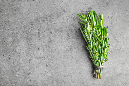 Bunch of fresh rosemary on gray table, top view with space for textの写真素材