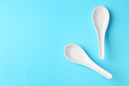 Miso soup spoons on blue background, flat lay. Space for textの写真素材