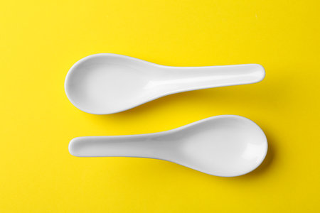 Miso soup spoons on yellow background, flat layの写真素材