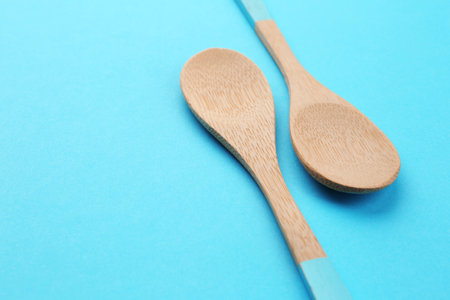 Clean empty bamboo spoons on blue background, space for textの写真素材