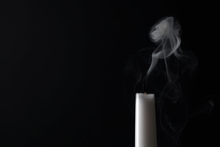 Smoldering candle wick and smoke on dark background, space for textの写真素材