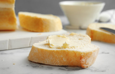 Slice of bread with butter on marble tableの写真素材