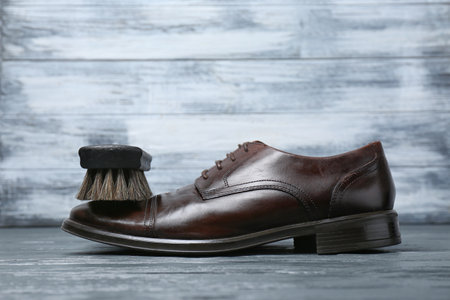 Men's leather shoes and cleaning brush on gray tableの写真素材