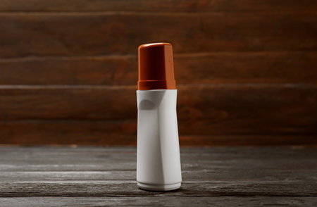 Bottle of liquid shoe polish on wooden table. Footwear care itemの写真素材