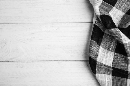 Black plaid kitchen towel on white wooden background, top view. Space for textの写真素材