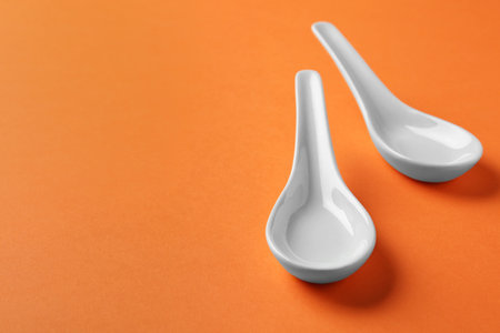 Miso soup spoons on orange background. Space for textの写真素材