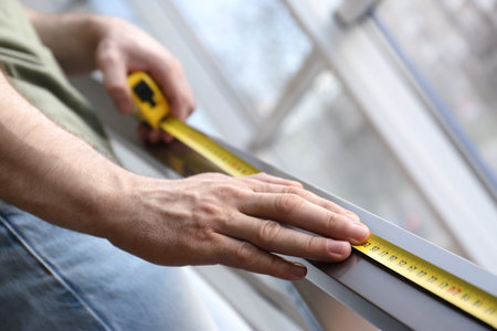 Man measuring metal railing, closeup. construction toolの写真素材
